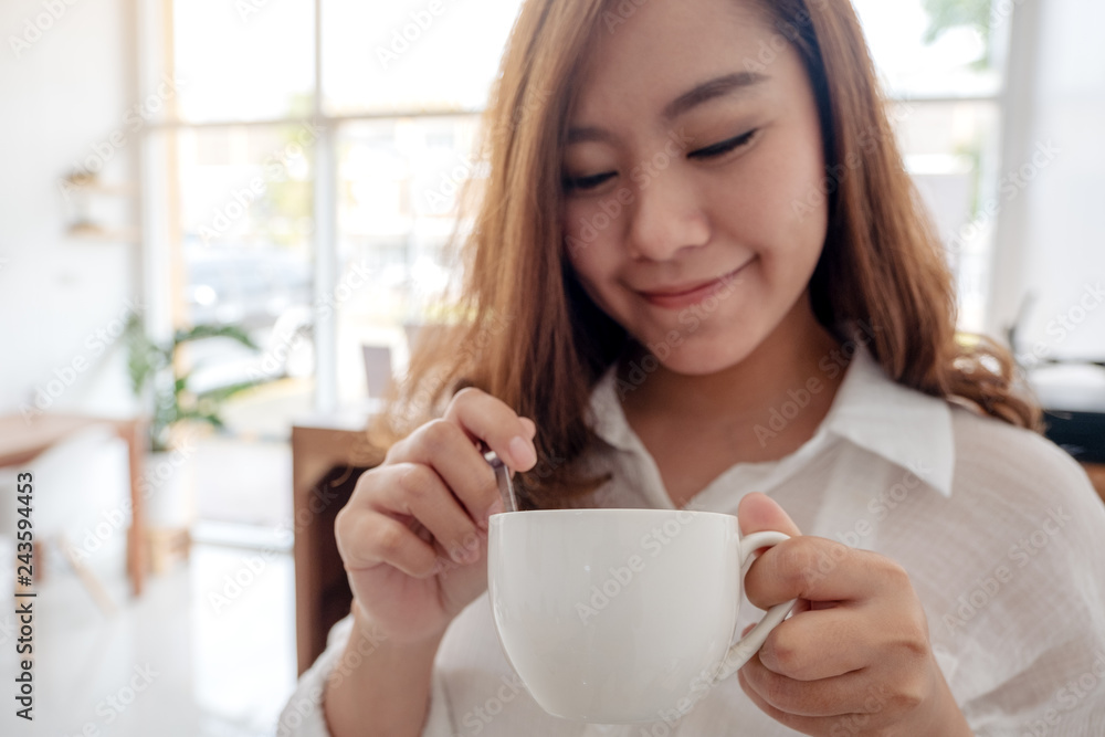 A beautiful Asian woman holding and drinking hot coffee with feeling good in cafe A beautiful Asian woman holding and drinking hot coffee with feeling good in cafe