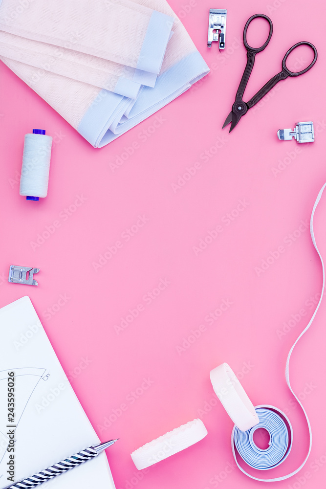 Woman hobby. Set for tailor shop with thread, scissors, fabric on pink background top view copy space Woman hobby. Set for tailor shop with thread, scissors, fabric on pink background top view copy space