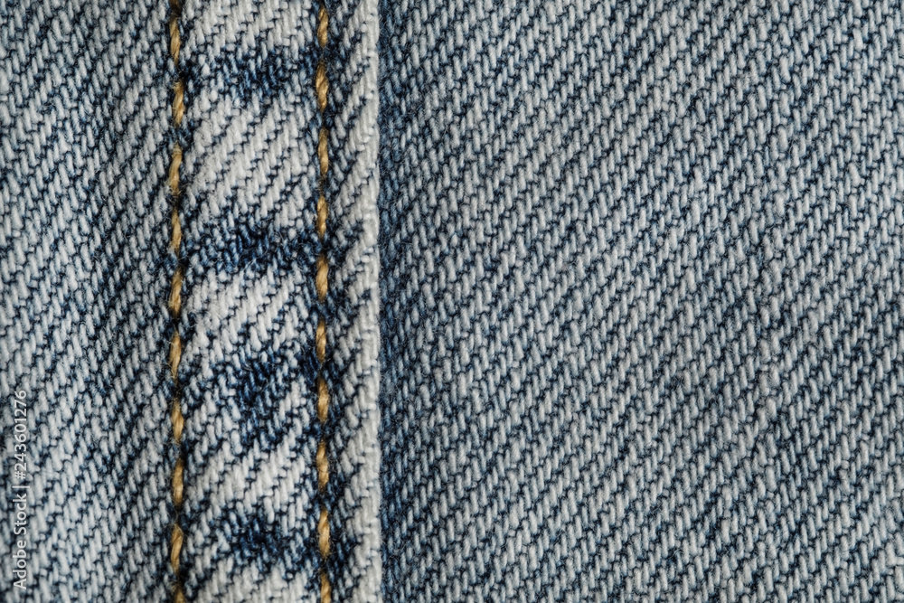 Blue jeans fabric macro seam pattern blurred background. Denim background texture for design. Blue jeans fabric macro seam pattern blurred background. Denim background texture for design.