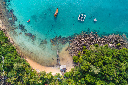 Aerial view of exotic turquoise sea with white beach green tree island