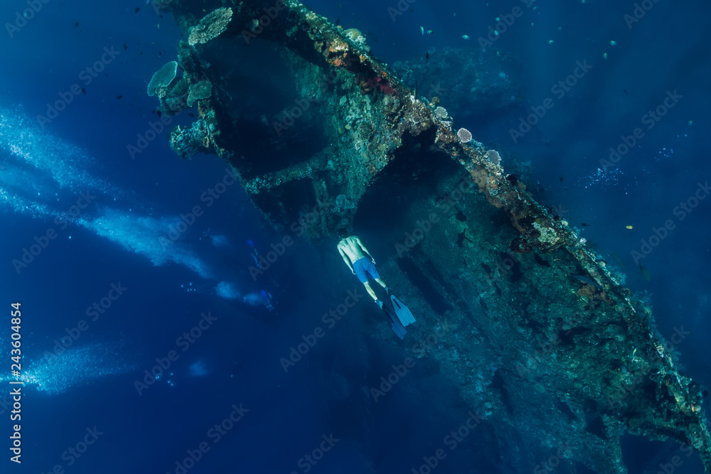 Free diver man dive at shipwreck, underwater