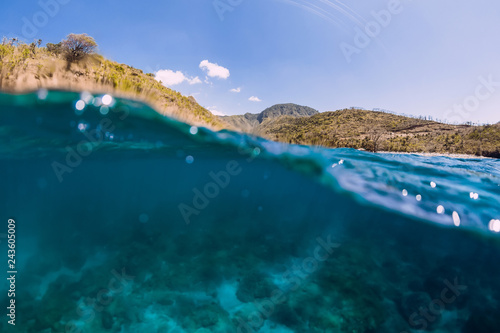 Underwater scene with clear ocean water and mountains.