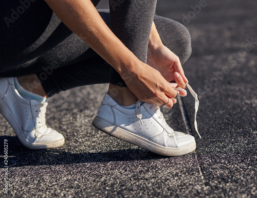 Running shoes - closeup of woman tying shoe laces.