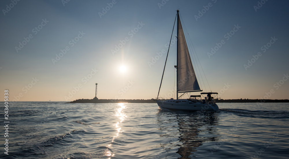 Sailboat going past jetty in the Channel Islands harbor in Oxnard California United States