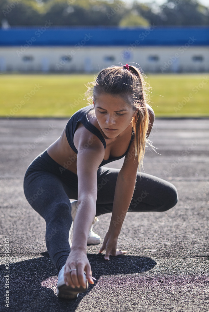 Young runner fit woman streching before exercises outdoors. Athletic female strech after workout outside. Sport and people concept. Young runner fit woman streching before exercises outdoors. Athletic female strech after workout outside. Sport and people concept.