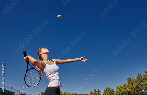 a Girl playing tennis on the court on a beautiful sunny day © shyshka