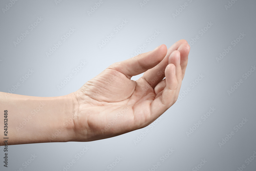 Hand holding or asking or giving something on gray background Hand holding or asking or giving something on gray background