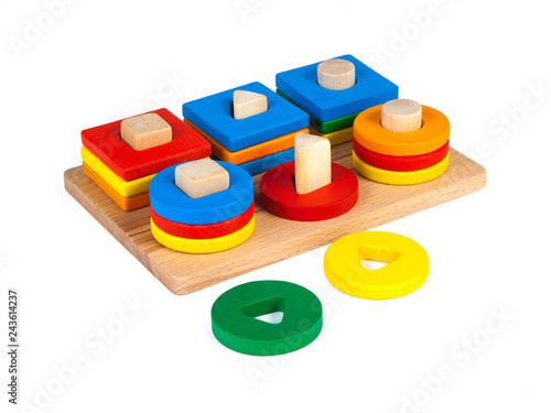 Photo of a wooden toy children's sorter with small wooden details in the form of geometric shapes (rectangle, square, circle, triangle), in different colors on a white isolated background