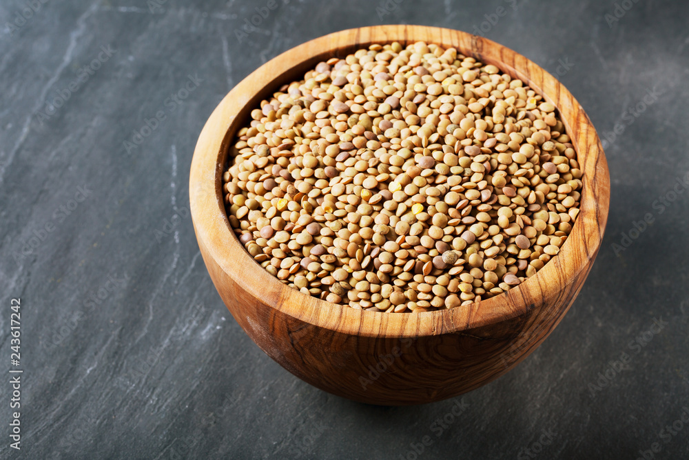 Dried lentils in a wooden bowl on a wooden table Dried lentils in a wooden bowl on a wooden table