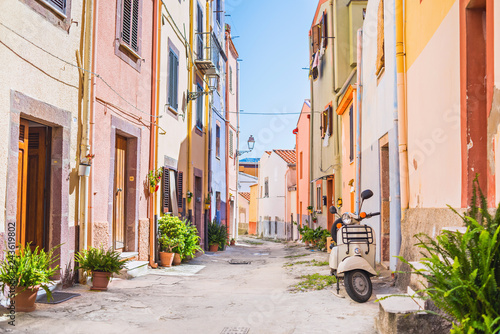 Fototapeta Naklejka Na Ścianę i Meble -  Old-fashioned scooter in a picturesque street of tiny Bosa town, Sardinia island