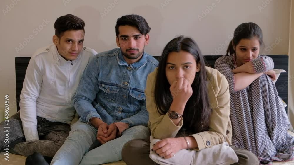 Friends focused and watching a drama cinema film on the television as of the guys has tears rolling down his eyes with emotions Friends focused and watching a drama cinema film on the television as of the guys has tears rolling down his eyes with emotions