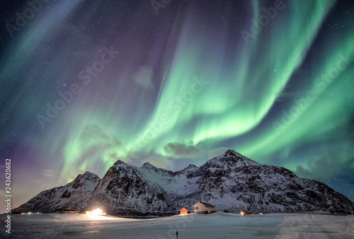 Canvastavla Aurora borealis with starry over snow mountain range with illumination house in