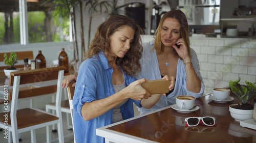 Lesbian couple dating in cafe. Two beautiful women taking selfie photo in slow motion
