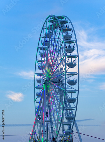 part of a big wheel in front of blue sky at evening time 