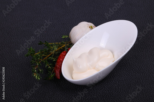 Mayonnaise sauce in the white bowl served thyme and garlic