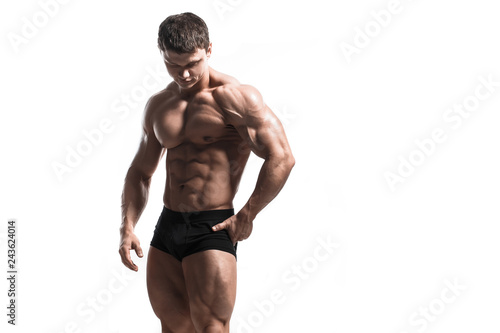 Handsome power athletic man pumping up muscles isolated over white. Strong bodybuilder with perfect shape body and six pack, abs, shoulders, biceps, triceps and chest.