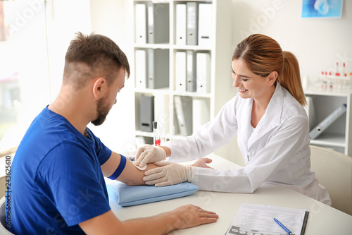 Female doctor preparing patient for blood draw in clinic
