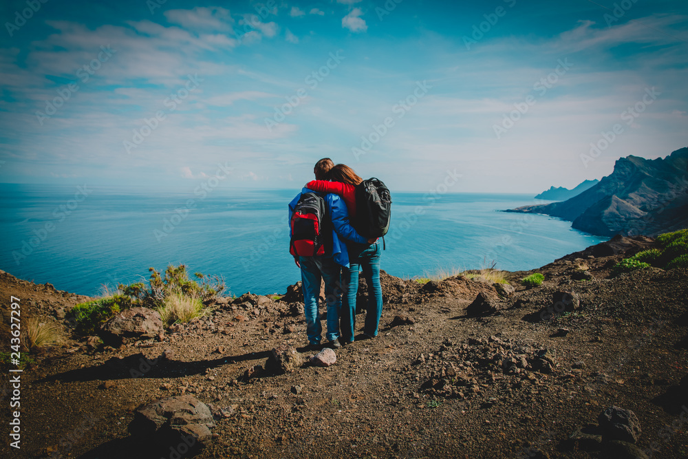 happy loving couple hiking in mountains at sea