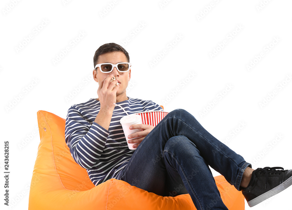 Fototapeta premium Young man with popcorn watching movie on white background