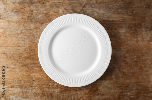 Empty ceramic plate on wooden background photo