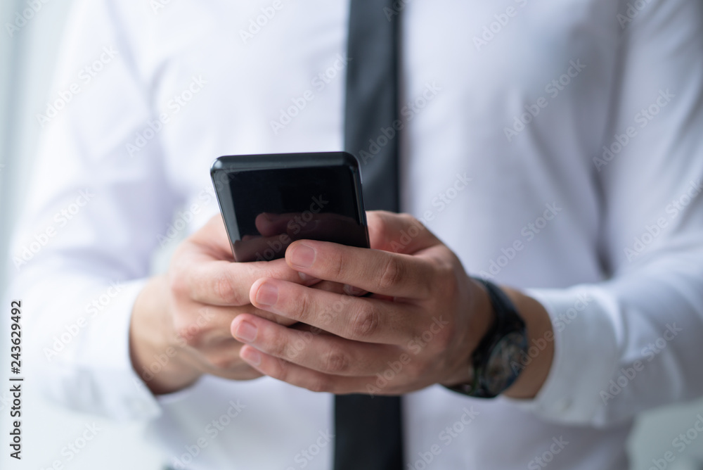 Closeup of business man browsing on smartphone. Entrepreneur holding digital device. Communication and technology concept. Cropped front view. Closeup of business man browsing on smartphone. Entrepreneur holding digital device. Communication and technology concept. Cropped front view.