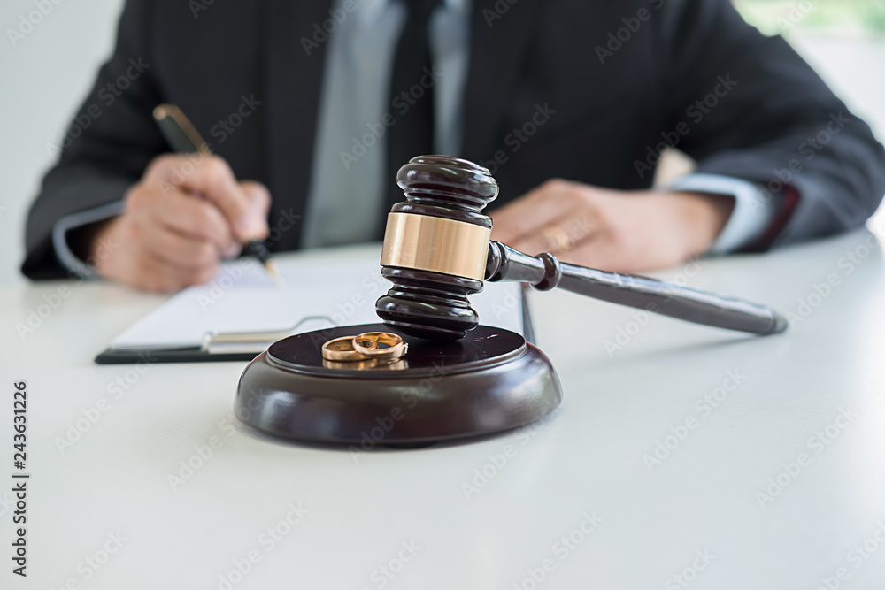 Judge gavel with Justice lawyers deciding, consultation on marriage divorce between married couple and signing divorce documents on table. Concepts of Law and Legal sevices. Judge gavel with Justice lawyers deciding, consultation on marriage divorce between married couple and signing divorce documents on table. Concepts of Law and Legal sevices.