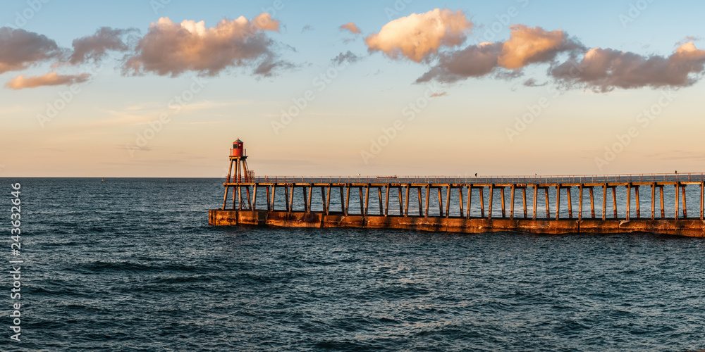 Whitby, North Yorkshire, England, UK - looking at the East Pier, seen from the West Pier Lighthouse Whitby, North Yorkshire, England, UK - looking at the East Pier, seen from the West Pier Lighthouse