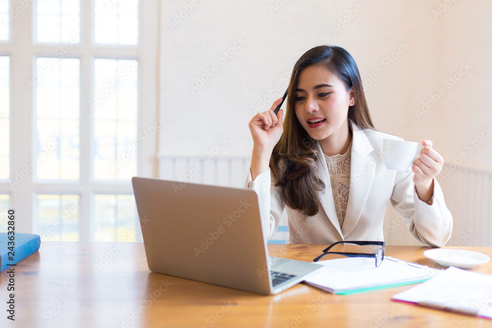 Protrait of Beautiful businesswoman sitting at desk and working with laptop computer. Protrait of Beautiful businesswoman sitting at desk and working with laptop computer.