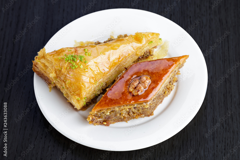 Traditional arabic dessert baklava with walnuts and cardamom, on a wooden table. Homemade baklava with nuts and honey. Traditional arabic dessert baklava with walnuts and cardamom, on a wooden table. Homemade baklava with nuts and honey.