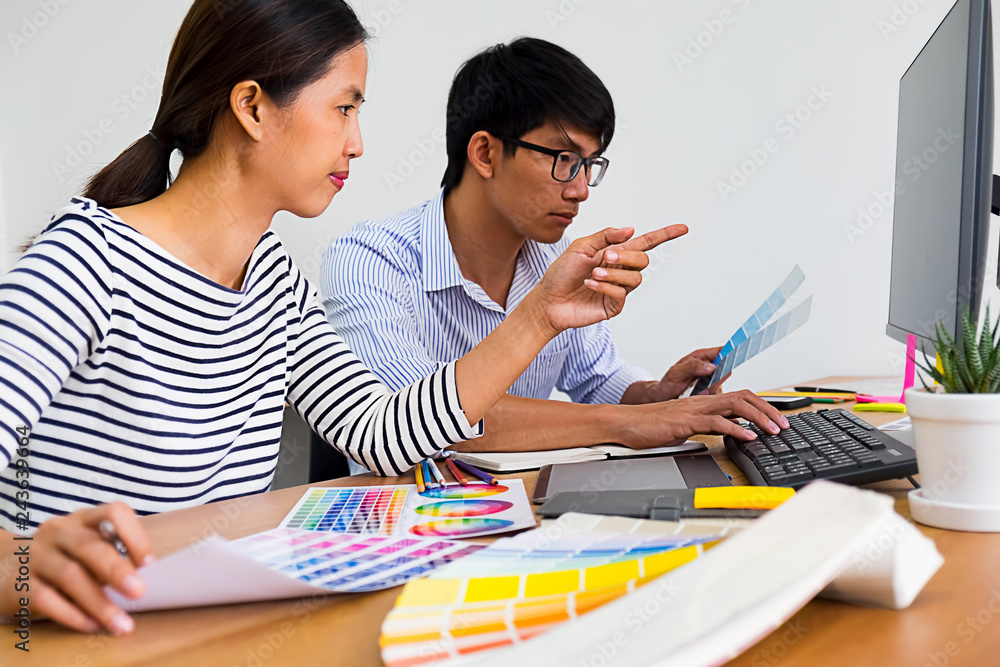 Graphic design with color swatches and tablet on a desk. Graphic designer drawing something on tablet at the office with work tools and accessories. Graphic design with color swatches and tablet on a desk. Graphic designer drawing something on tablet at the office with work tools and accessories.