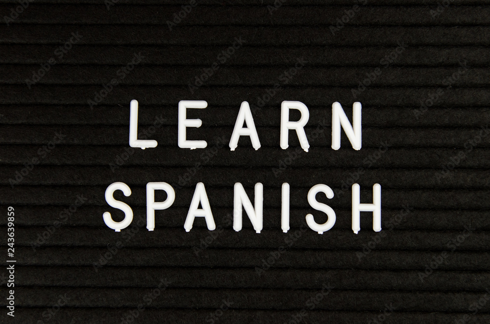 Learn Spanish language, modern looking sign on black background Learn Spanish language, modern looking sign on black background