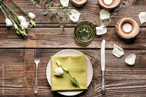 Beautiful table setting with floral decor on wooden background