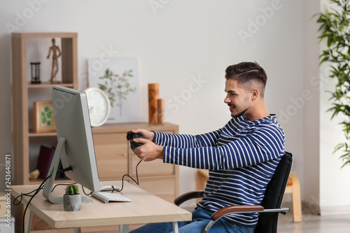Young man playing computer ...