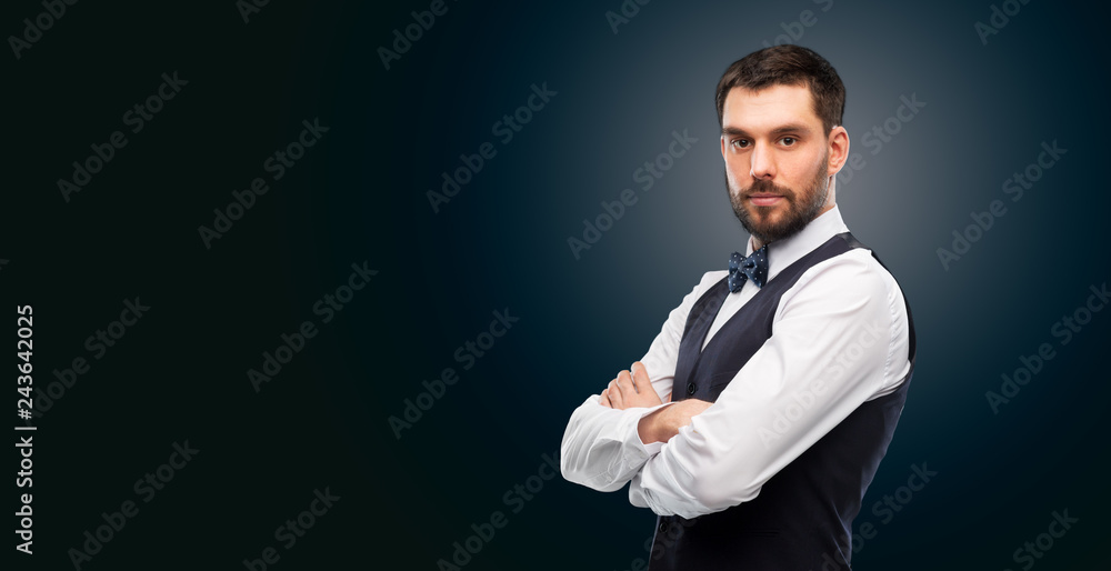 people concept - serious man in white shirt, waistcoat and bowtie over black background people concept - serious man in white shirt, waistcoat and bowtie over black background