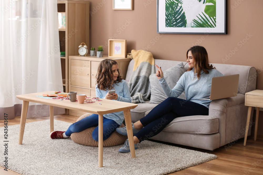 Cute daughter keeping mother from her work at home Cute daughter keeping mother from her work at home