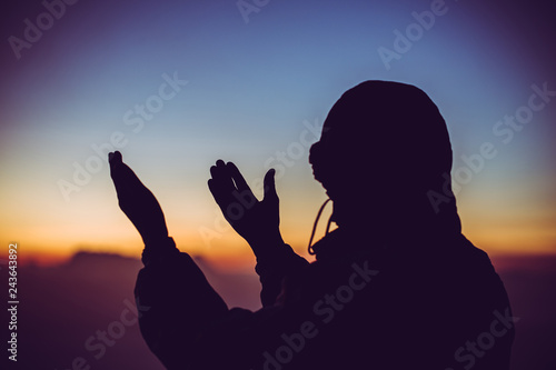 Faith of christian concept: Spiritual prayer hands over sun shine with blurred beautiful sunrise background