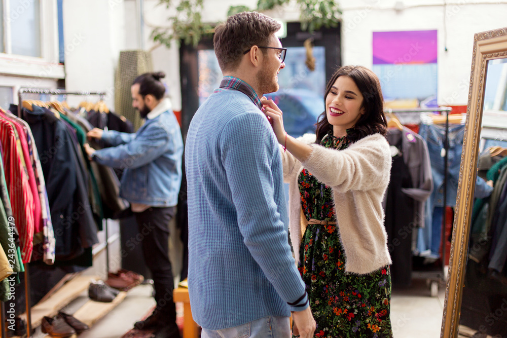 sale, shopping, fashion and people concept - couple choosing clothes at vintage clothing store sale, shopping, fashion and people concept - couple choosing clothes at vintage clothing store