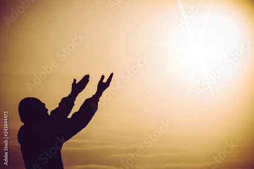 Faith of christian concept: Spiritual prayer hands over sun shine with blurred beautiful sunrise background