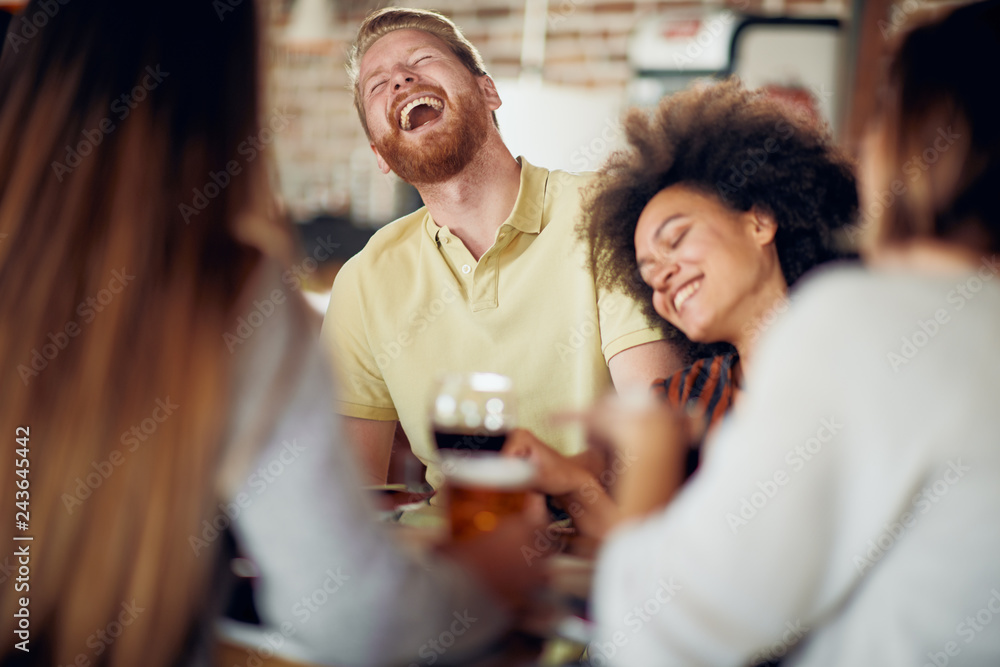 Friends chatting and drinking alcohol while sitting at restaurant. Multi ethnic group. Friends chatting and drinking alcohol while sitting at restaurant. Multi ethnic group.
