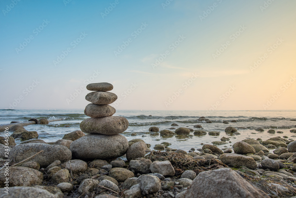 Fototapeta premium Stacked stones in balance on the lakeside, Lake Garda, Italy