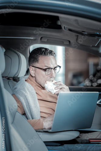 Businessman preparing for meeting reading documents on laptop © Viacheslav Yakobchuk