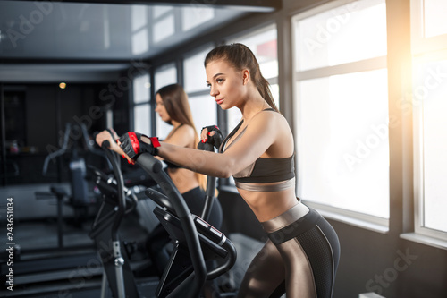Attractive young sports woman is working out in gym. Doing cardio training on treadmill. Running on treadmill