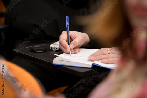 Journalist is taking notes during a conference