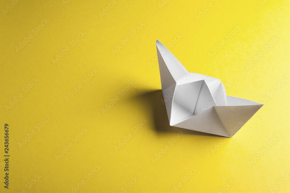 Paper boat on a yellow background with copyspace Paper boat on a yellow background with copyspace