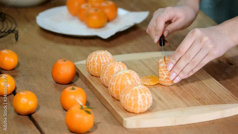 Closeup of woman hands slicing lime tangerine. Closeup of woman hands slicing lime tangerine.