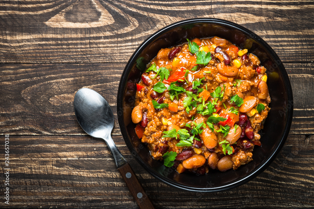 Chili con carne from meat and vegetables on wooden table top vie Chili con carne from meat and vegetables on wooden table top vie
