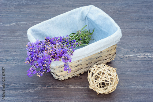 Fototapeta Naklejka Na Ścianę i Meble -  Fresh lavender in wicker basket, and beige wicker ball on grey wooden background.
