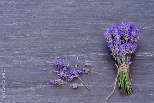 Fresh bouquet of lavender tied up with brown hemp on grey wooden background.