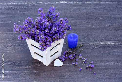 Fototapeta Naklejka Na Ścianę i Meble -  Fresh lavender in white basket, purple candle and heart on grey wooden background.