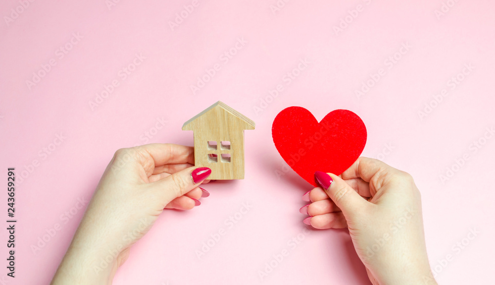 A girl holds a house and heart in her hands. The concept of affordable housing. A dream is to buy a house. Accumulation on the apartment. Property rental. Sale and mortgage real estate. Sweet Home A girl holds a house and heart in her hands. The concept of affordable housing. A dream is to buy a house. Accumulation on the apartment. Property rental. Sale and mortgage real estate. Sweet Home